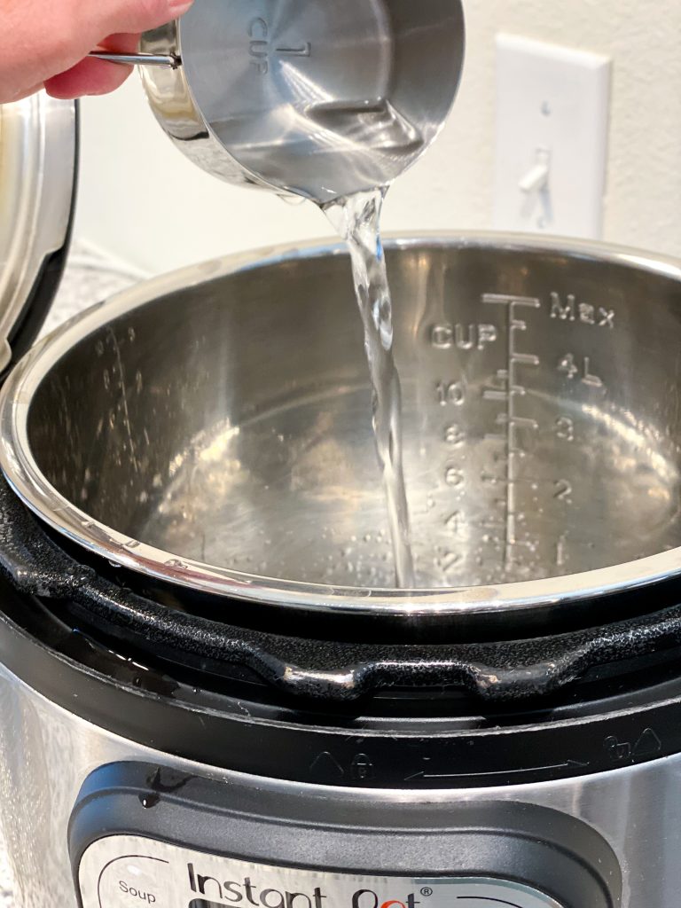 picture of one cup of water being poured into instant pot